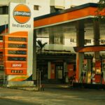 A view of an IndianOil gas station with pumps and signage in a city environment.